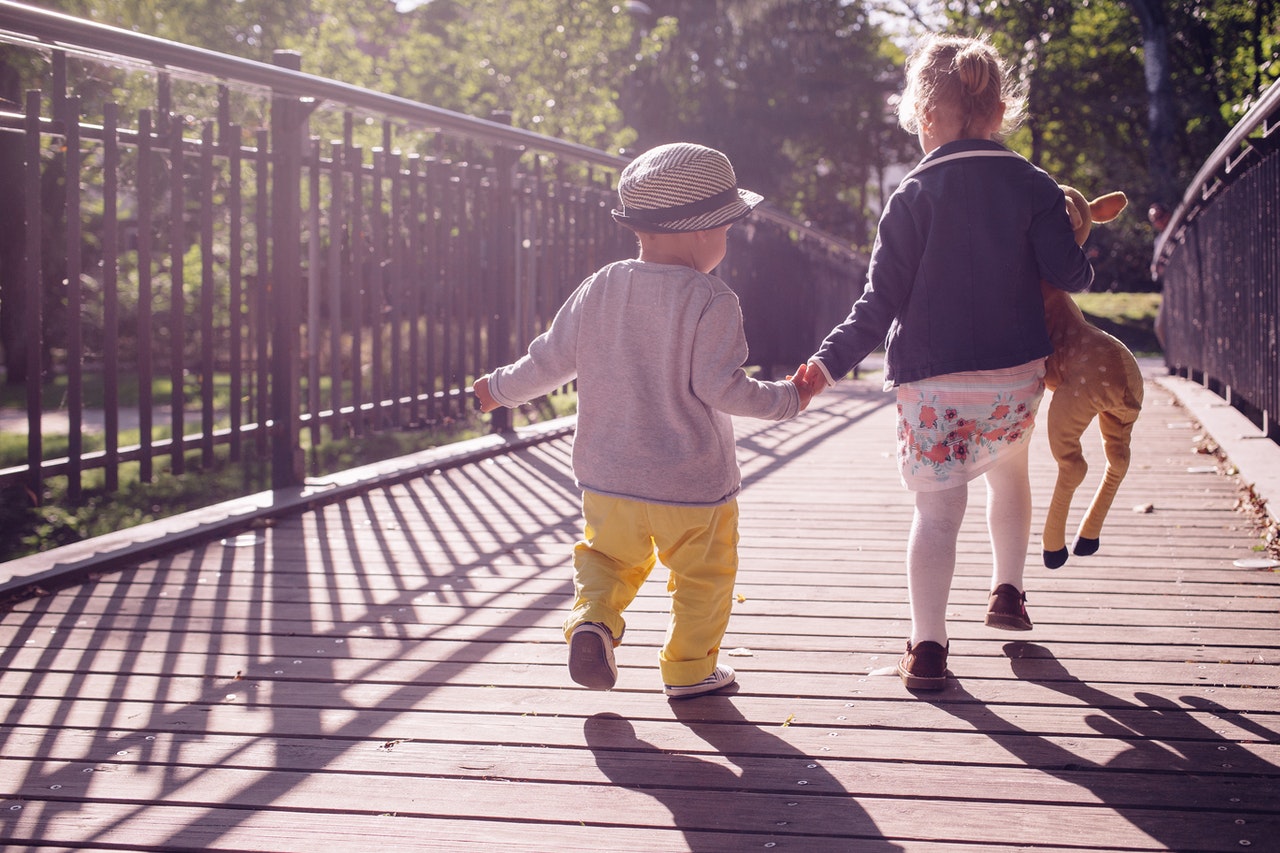 Laufende Kinder von hinten auf einer Brücke